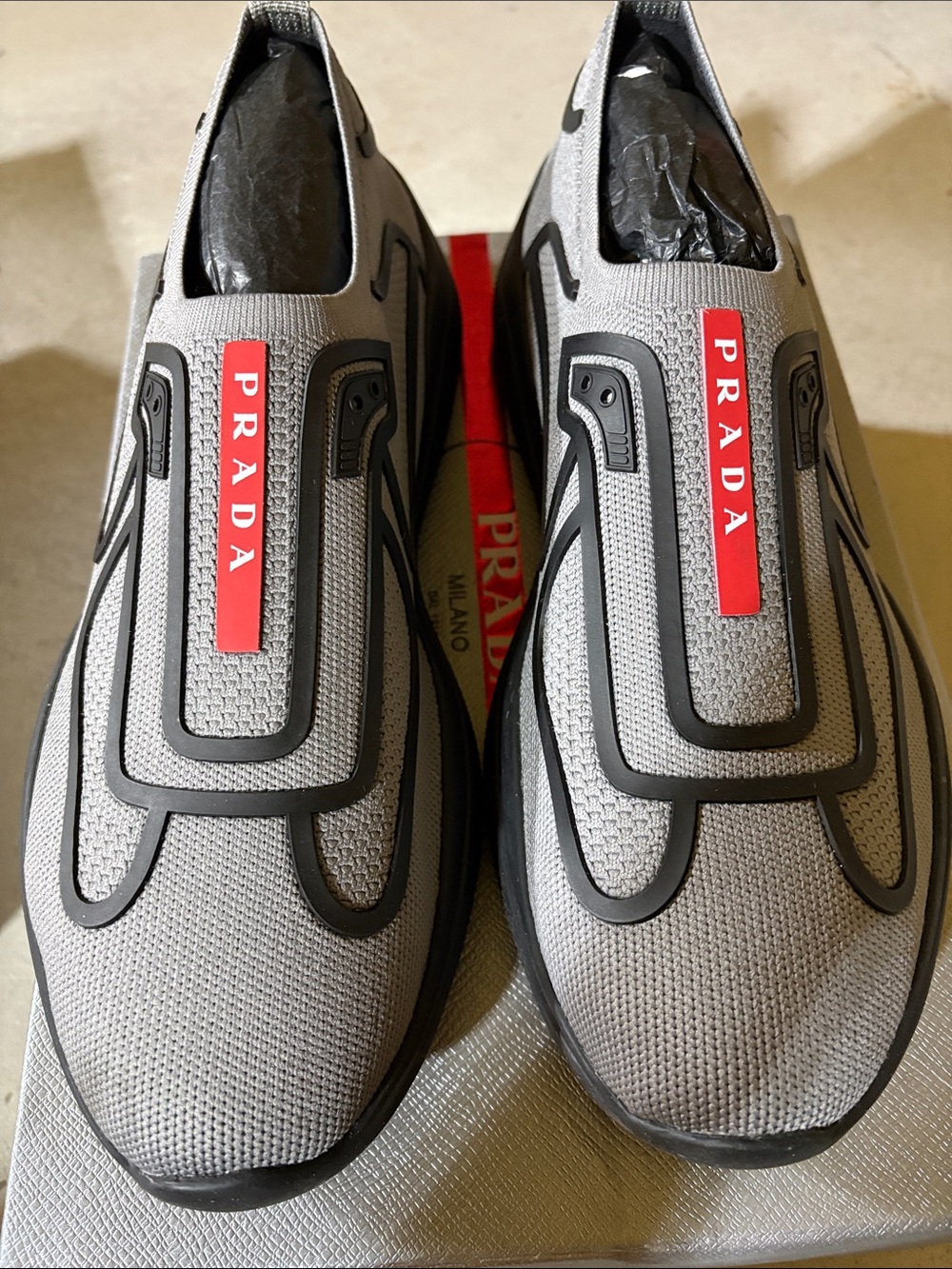 Prada Gray Slip-On Sneakers with Red Logo Tab